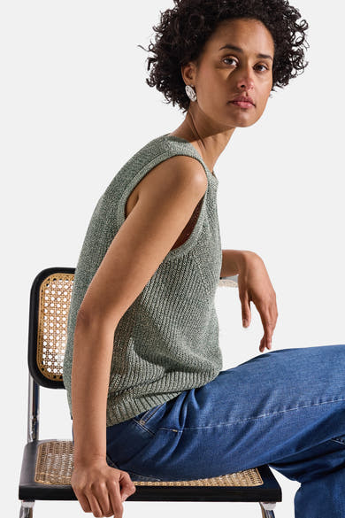 Top sans manches vert de Street One, porté avec un jean, sur une chaise en osier.