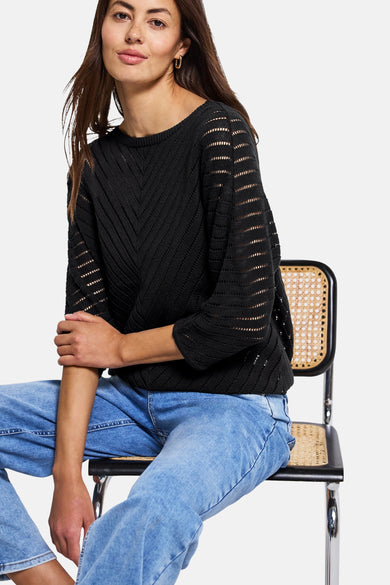 Zwarte rondehals trui van STREET ONE met ajourpatroon, gedragen met een blauwe jeans.