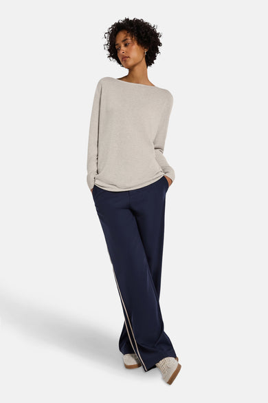 Top uni manches longues beige de Street One, porté avec un pantalon bleu marine à rayures latérales.