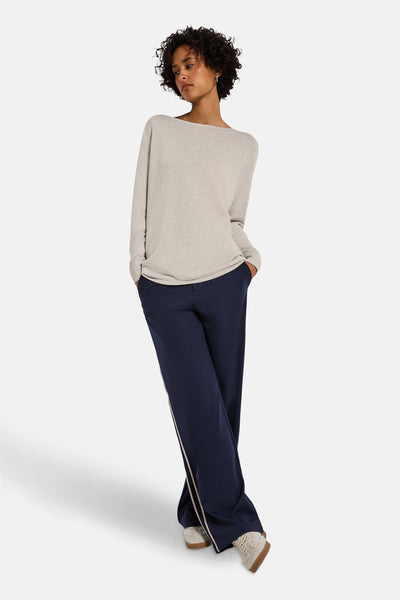 Top uni manches longues beige de Street One, porté avec un pantalon bleu marine à rayures latérales.