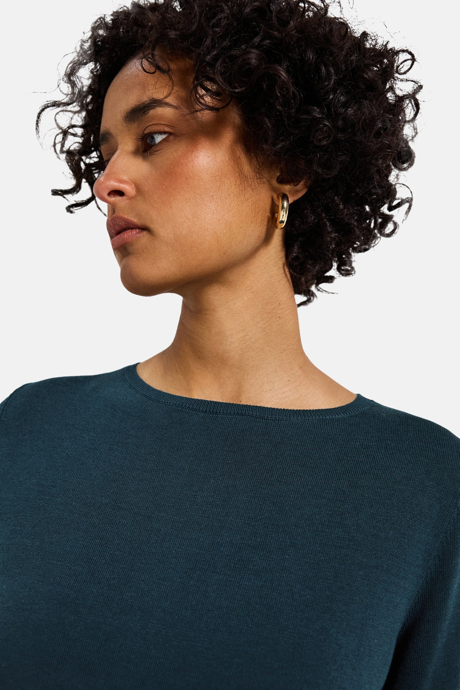 Top met lange mouwen blauw van Street One, gedragen met gouden oorbellen.