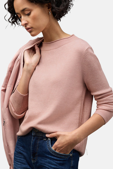 Roze trui van STREET ONE, gedragen met een wijde jeans en een jas in dezelfde kleur.