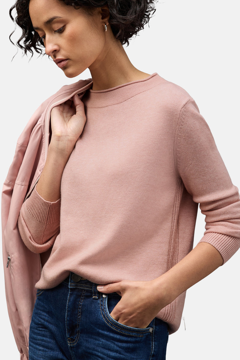 Roze trui van STREET ONE, gedragen met een wijde jeans en een jas in dezelfde kleur.