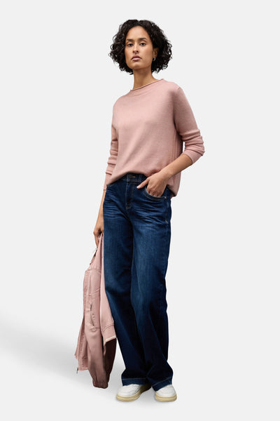 Pull rose de STREET ONE, porté avec un jean ample et une veste de la même couleur.
