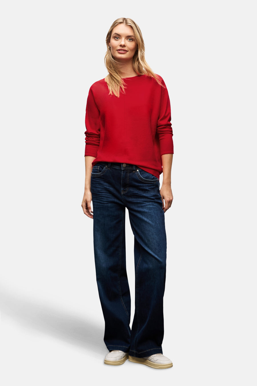 Pull à col rond rouge de STREET ONE porté avec un jean ample et des baskets blanches.