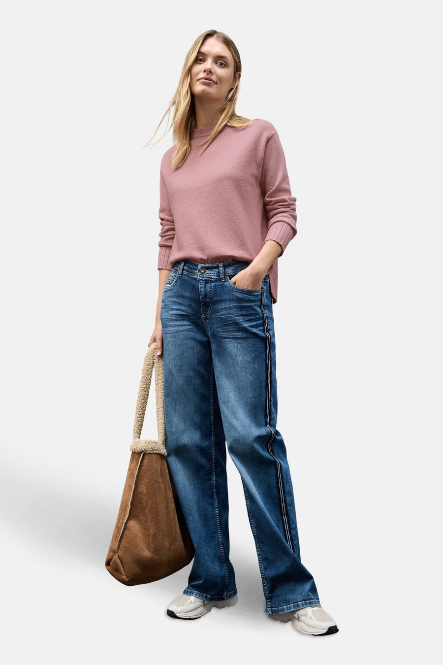 Ronde hals trui roze van STREET ONE, gedragen met een wijde gestreepte jeans en een suède tas.