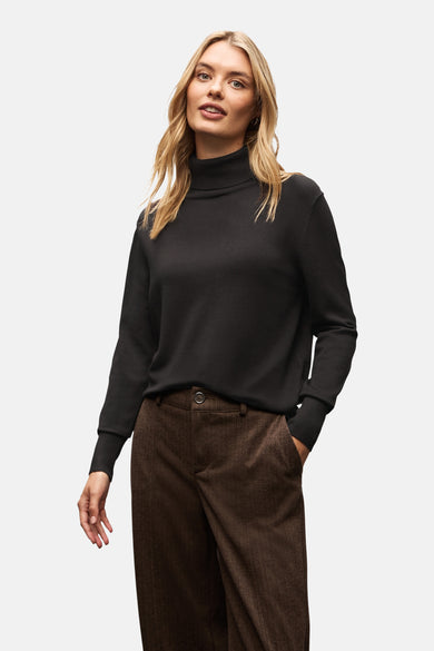 Pull col montant noir de Street One, porté avec un pantalon à chevrons marron.