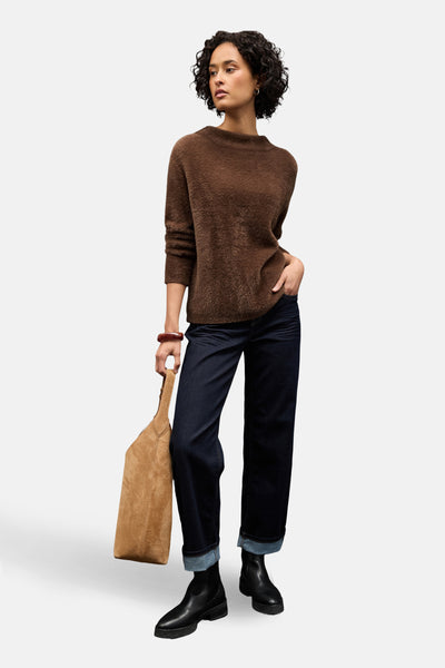 Pull col rond brun de Street One porté avec un jean bleu foncé retroussé et des bottines noires.
