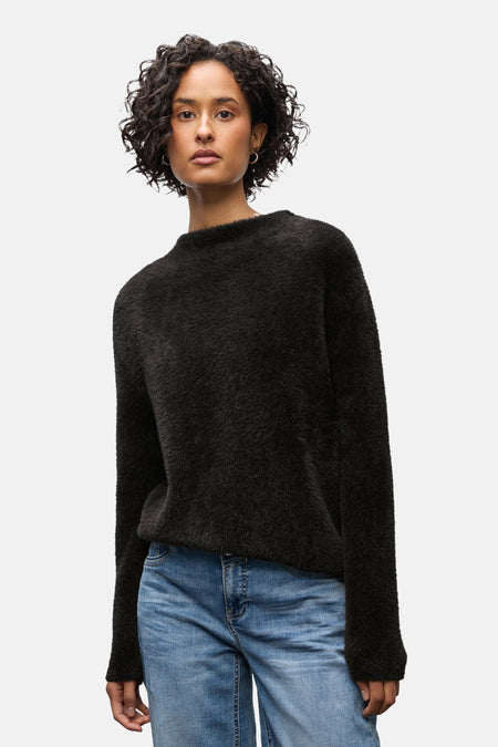 Ronde hals trui bruin van STREET ONE, gedragen met een blauwe jeans met omslag en zwarte enkellaarsjes.