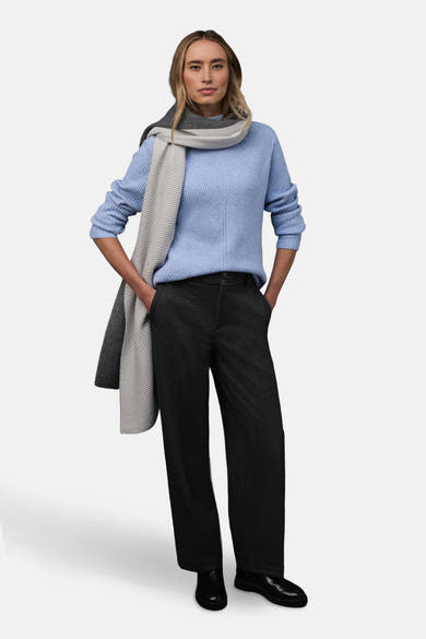 Pull col montant bleu de STREET ONE, porté avec un pantalon anthracite et une écharpe à rayures grises.
