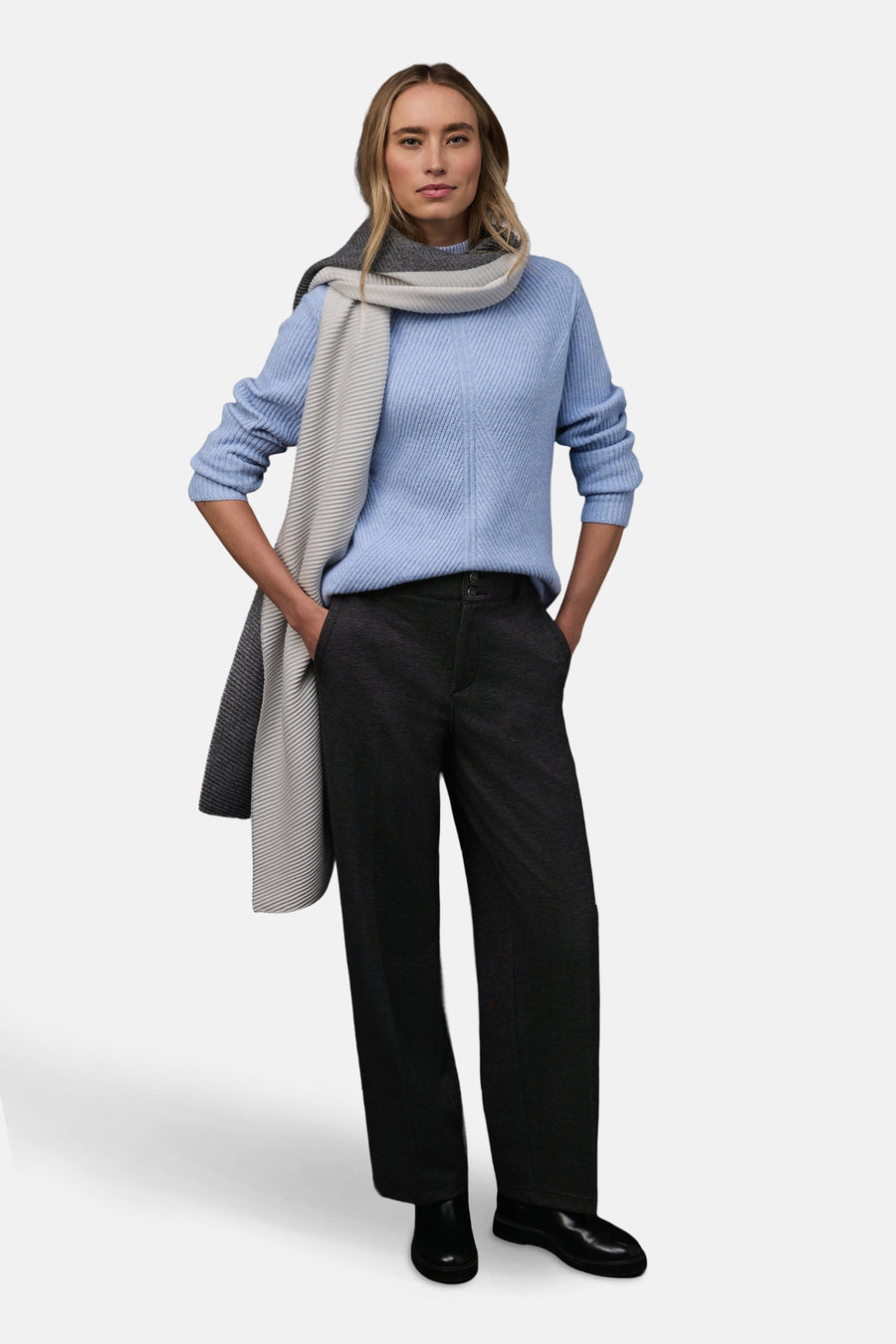 Pull col montant bleu de STREET ONE, porté avec un pantalon anthracite et une écharpe à rayures grises.
