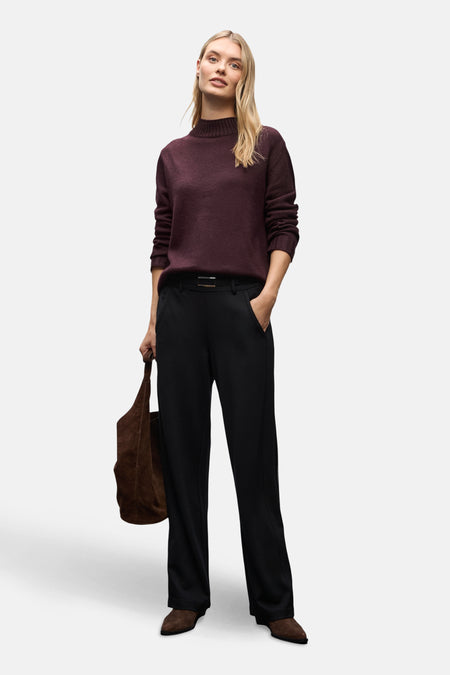 Pull à col rond bordeaux de STREET ONE, porté avec un pantalon noir et un sac en daim marron.