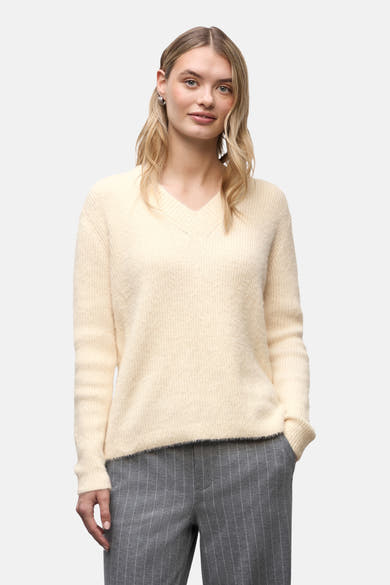 Ecru V-hals trui van Street One, gedragen met een grijze gestreepte broek en witte sneakers.