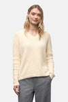 Ecru V-hals trui van Street One, gedragen met een grijze gestreepte broek en witte sneakers.