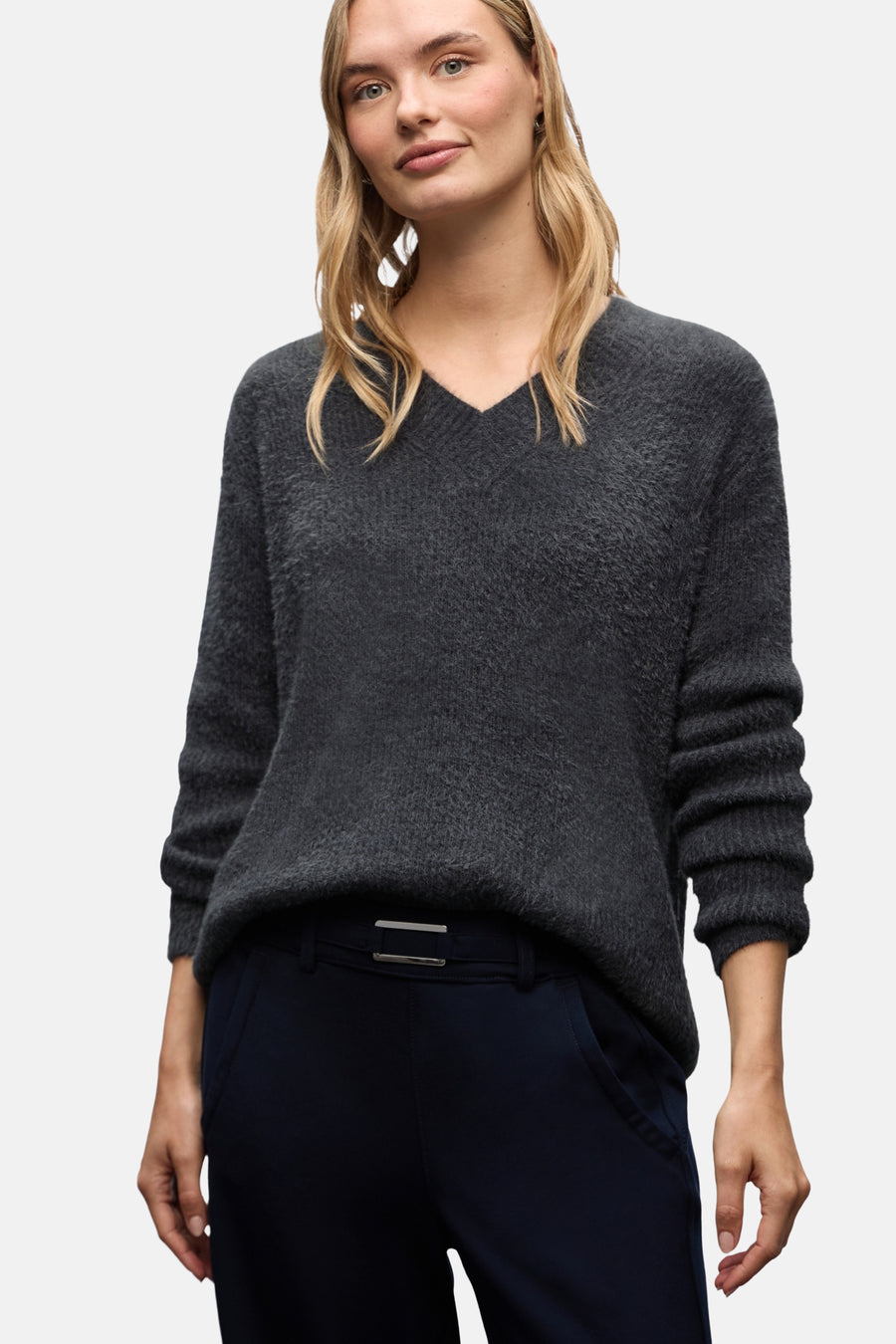 Grijze gemêleerde V-hals trui van Street One, gedragen met een marineblauwe broek en zwarte enkellaarsjes.