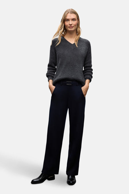 Pull col V gris de Street One porté avec un pantalon bleu marine et des bottines noires.
