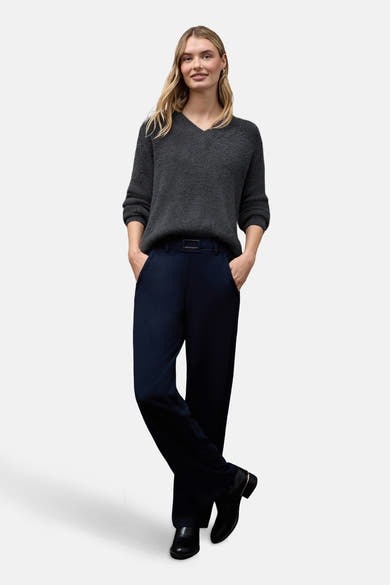 Pull col V gris chiné de Street One, porté avec un pantalon bleu marine et des bottines noires.
