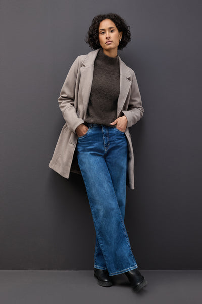 Bruine trui met opstaande kraag van Street One, gedragen met een beige jas en een blauwe jeans.