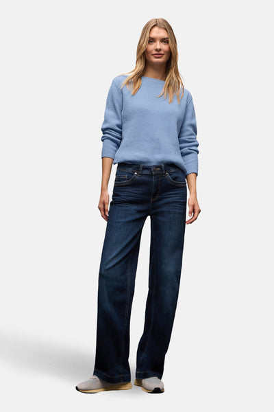 Pull col rond bleu par Street One, porté avec un jean bootcut bleu foncé et des baskets grises.
