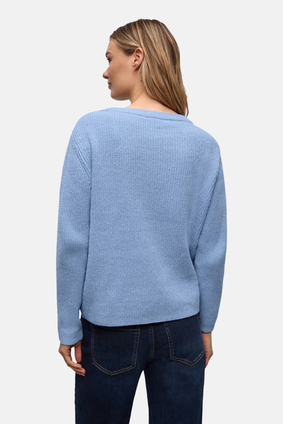 Pull col rond bleu de Street One, avec texture tricotée porté avec un jean bleu foncé.
