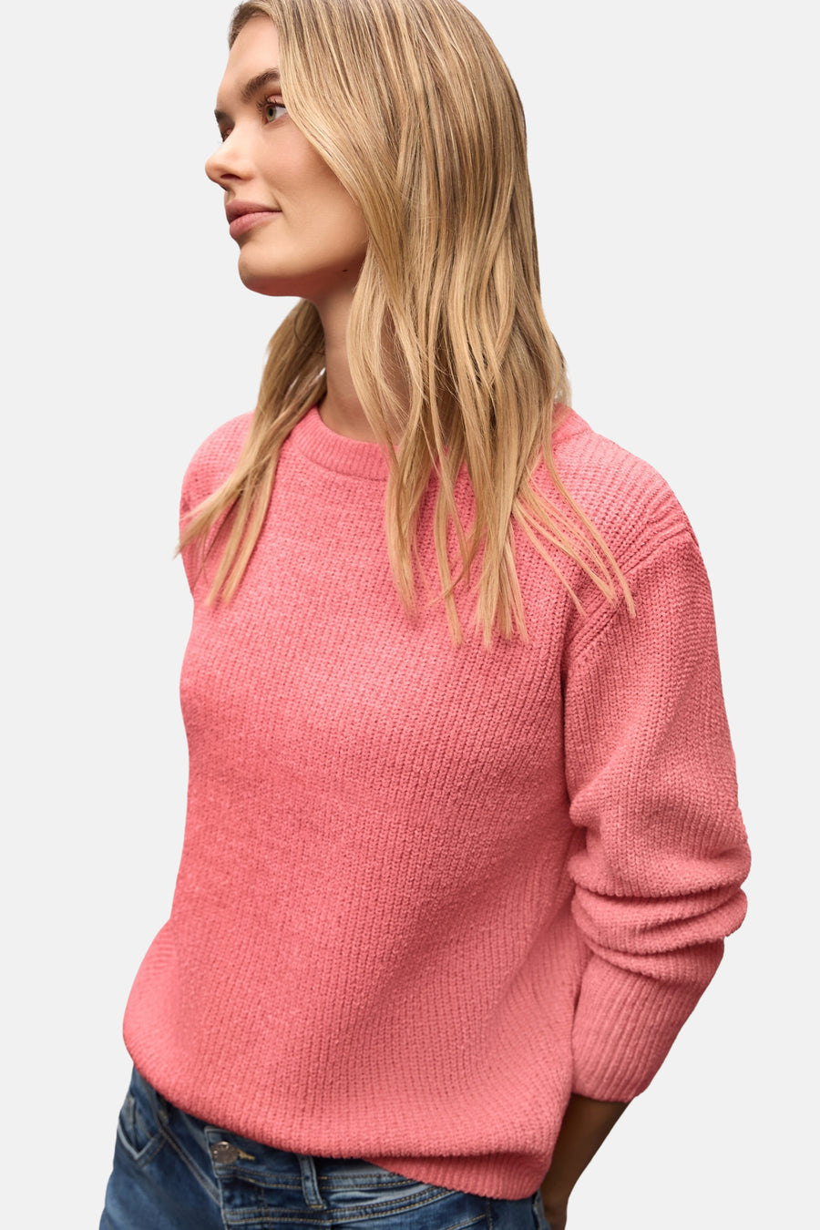 Ronde hals trui koraal van Street One, gedragen met een spijkerbroek en beige schoenen.