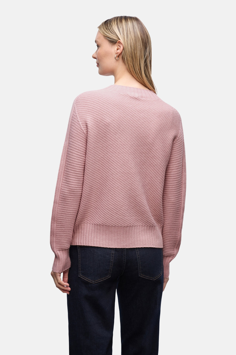 Pull col montant rose par Street One, texture côtelée diagonale sur le devant, porté avec un jean foncé.
