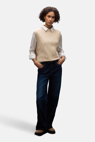 Débardeur beige de Street One, porté sur une chemise blanche à manches longues et un jean ample.