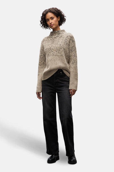 Pull col montant multicolore de Street One avec un motif moucheté et des jeans noirs larges.
