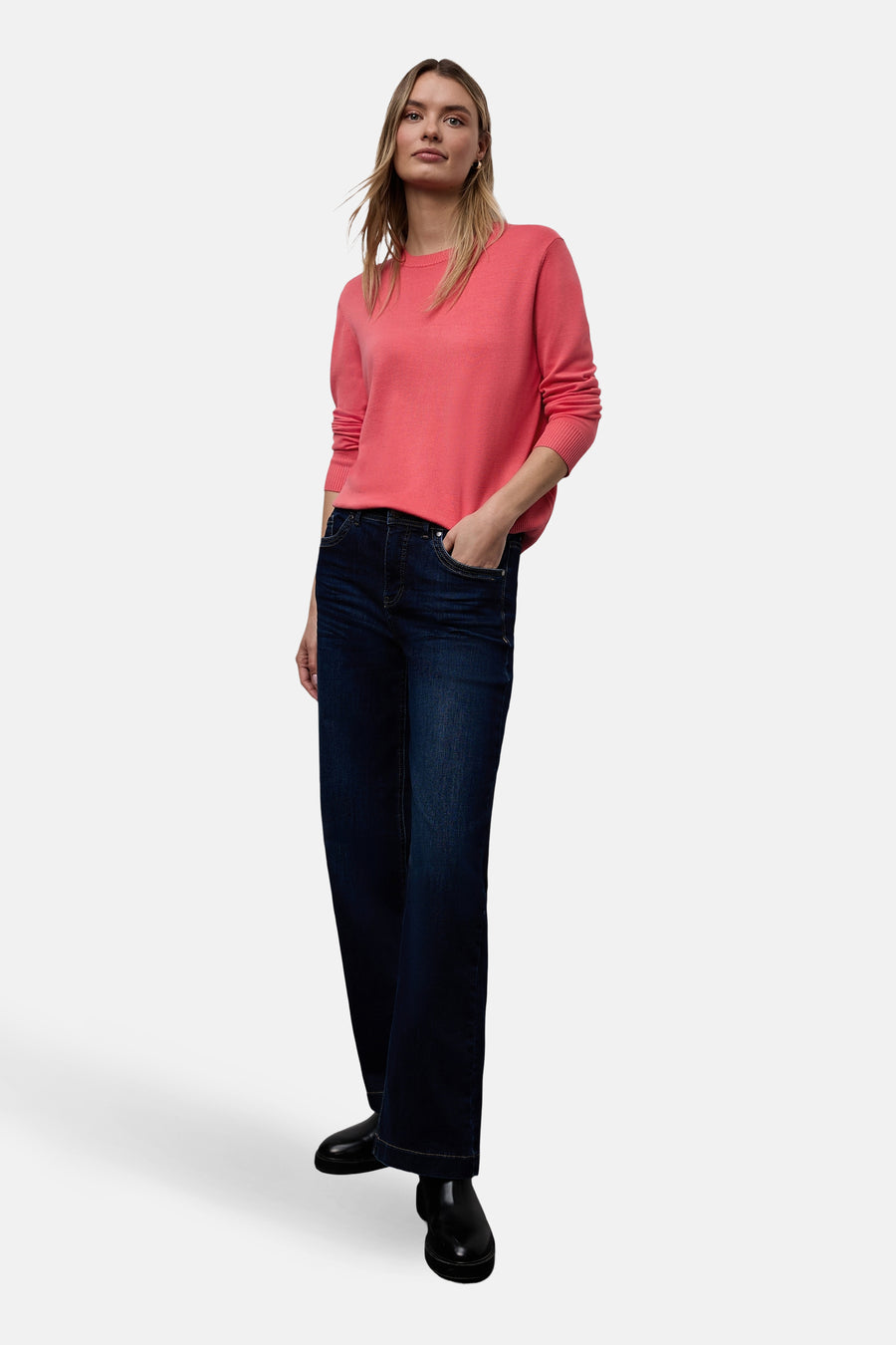 Pull col rond corail de STREET ONE, porté avec un jean foncé taille haute et des bottines noires.