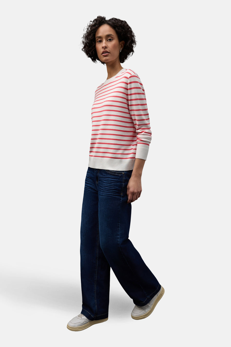 Pull col rond en coton rayé, de Street One, porté avec un jean large bleu et des chaussures blanches.