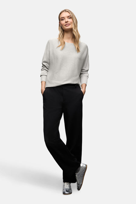 Top uni manches longues argenté de Street One porté avec un pantalon noir et des baskets argentées.