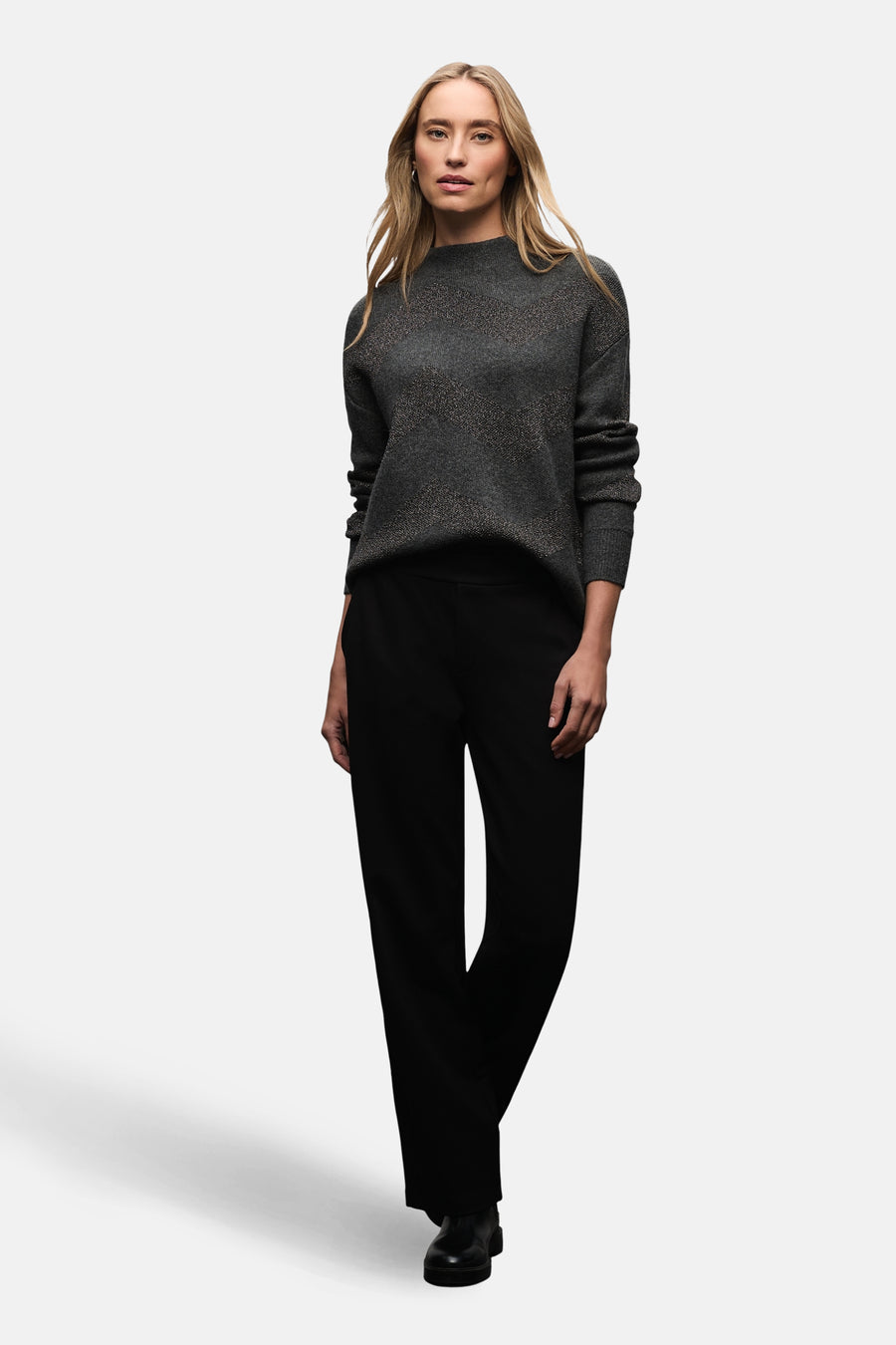 Pull col montant gris de Street One avec motif à chevrons, porté avec un pantalon noir.
