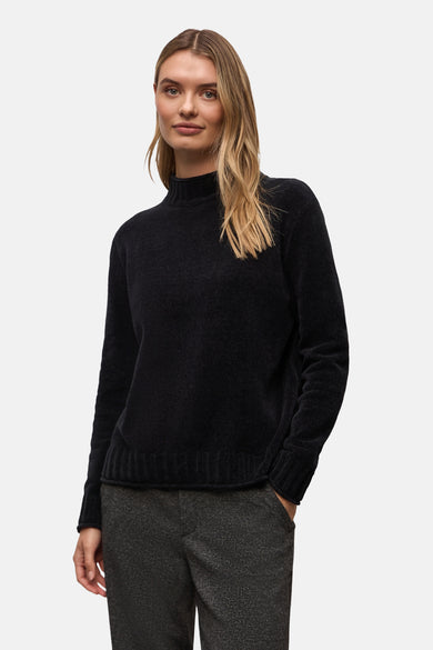 Pull col montant noir de Street One, porté avec un pantalon à motif tweed.
