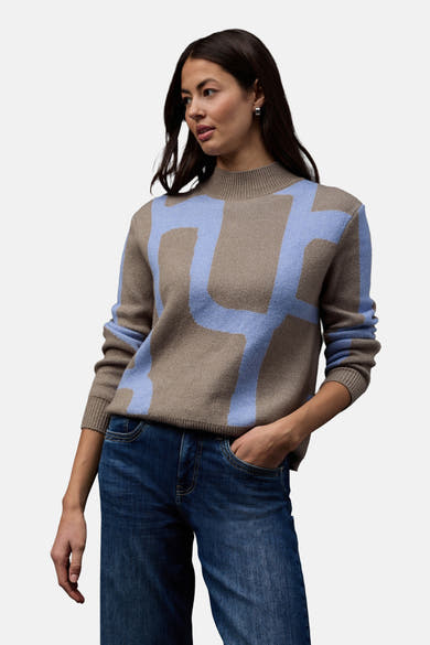 Pull col montant multicolore de STREET ONE, avec motif graphique bleu clair et porté avec un jean bleu foncé.
