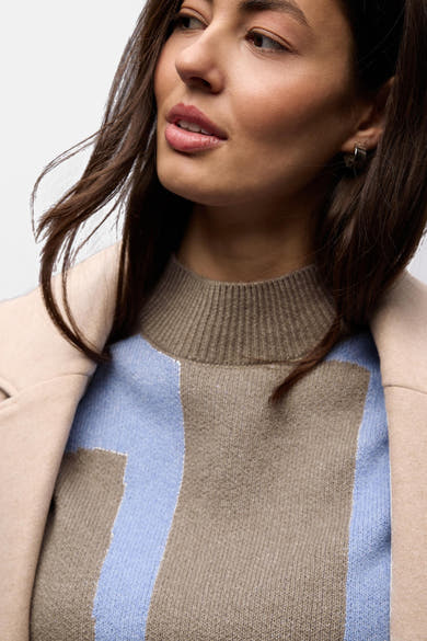 Pull col montant multicolore de Street One avec un motif géométrique porté avec un manteau beige.
