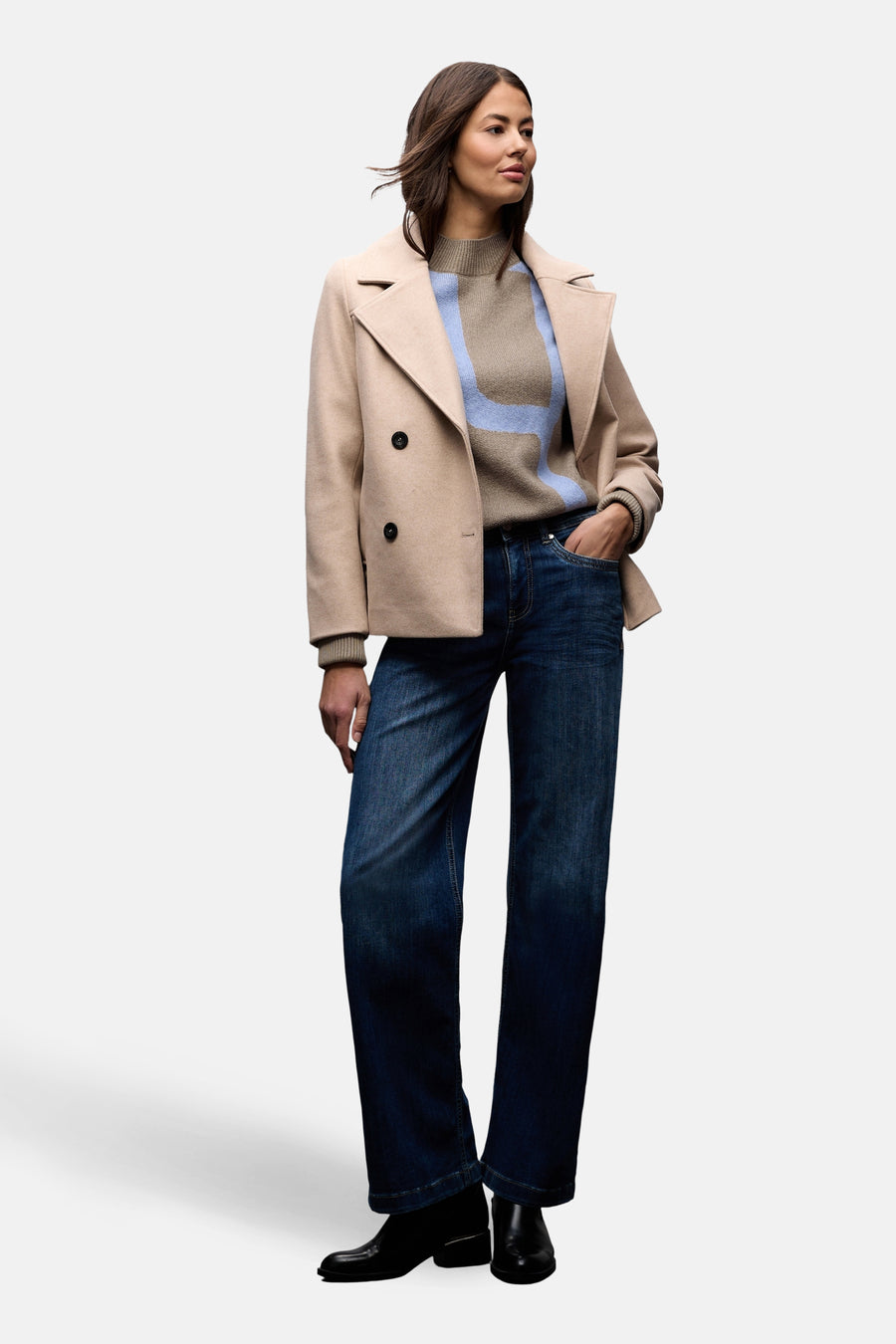 Pull col montant multicolore de Street One, porté avec un manteau beige court et un jean bleu foncé.