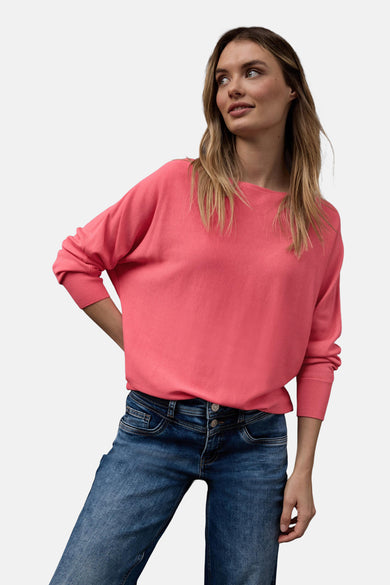 Ronde hals trui koraal van Street One, gedragen met een blauwe jeans en witte sneakers.