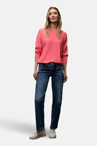 Pull à col rond corail de Street One, porté avec un jean bleu et des baskets blanches.