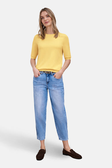 Pull col rond jaune de Street One, porté avec un jean bleu et des mocassins marron.