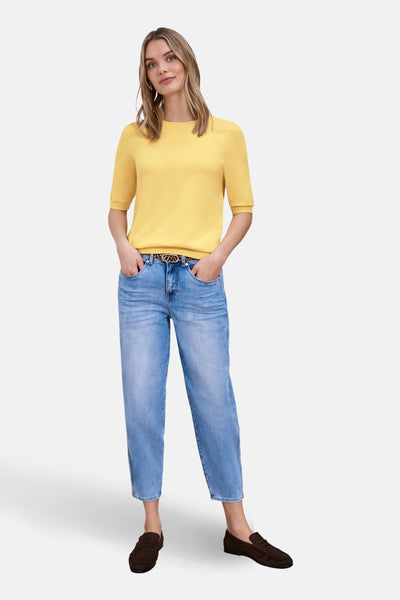 Pull col rond jaune de Street One, porté avec un jean bleu et des mocassins marron.
