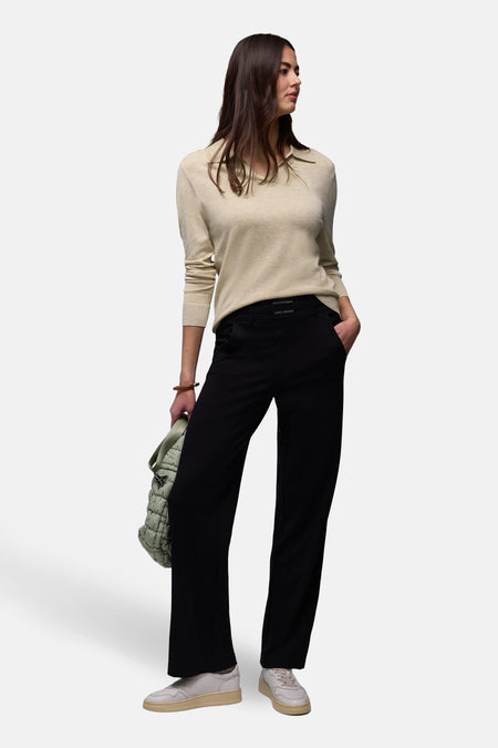 Polo beige de STREET ONE, manches longues, porté avec un pantalon noir et des baskets blanches.