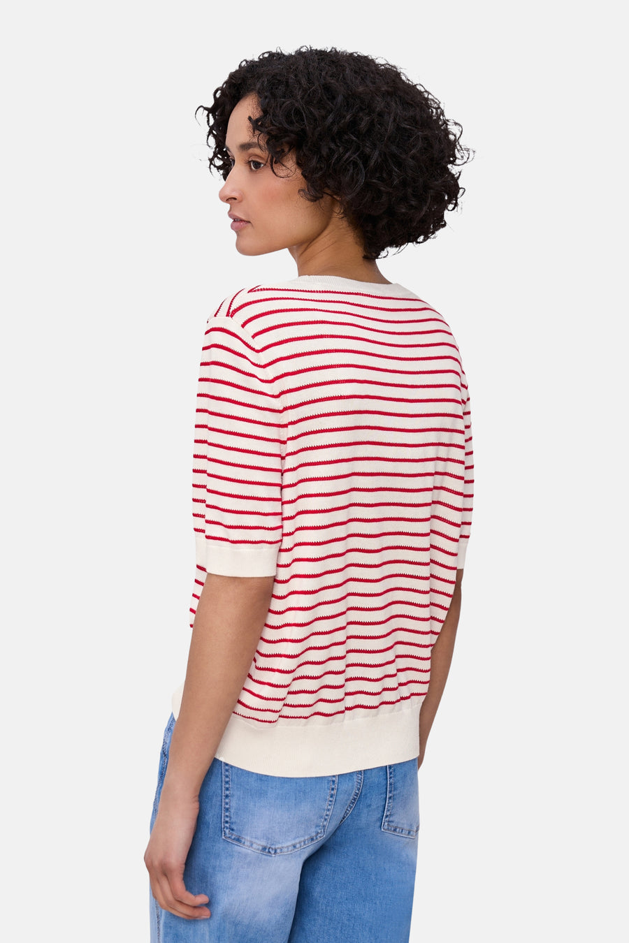 Pull multicolore col rond de STREET ONE, rayures rouges et blanches, porté avec un jean bleu.