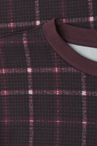 Multicolored plaid sweatshirt with ribbed crew neckline, close-up view showing dark maroon and black checkered pattern with pink accents