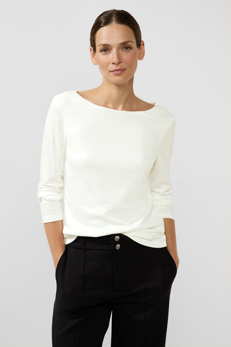 Top uni blanc à manches longues de Street One, porté avec un pantalon noir taille haute.