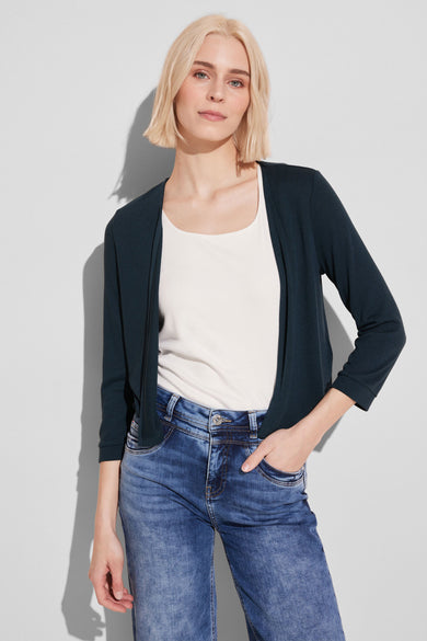 Gilet vert de STREET ONE porté sur un débardeur blanc et un jean bleu.