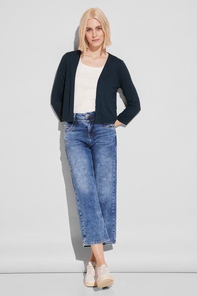 Gilet vert de STREET ONE porté par-dessus un t-shirt blanc et un jean bleu délavé.