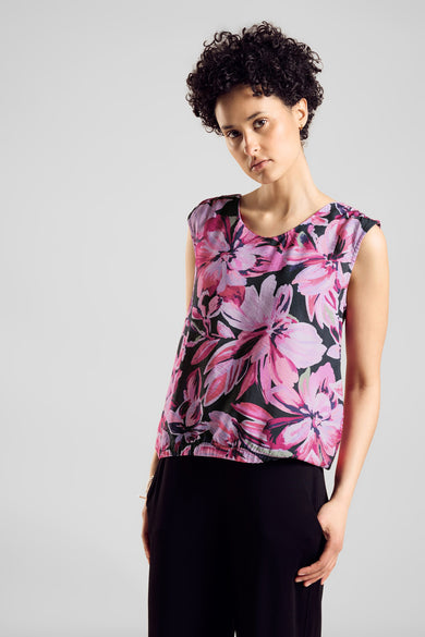 Top sans manches rose imprimé fleurs, de Street One, porté avec un pantalon noir.
