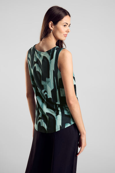 Top sans manches vert de STREET ONE, imprimé avec motifs abstraits noirs et turquoise, porté avec une jupe noire.
