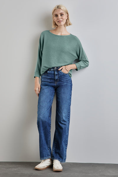 T-shirt vert clair de STREET ONE avec manches longues et texture gaufrée, porté avec jean bleu et baskets.