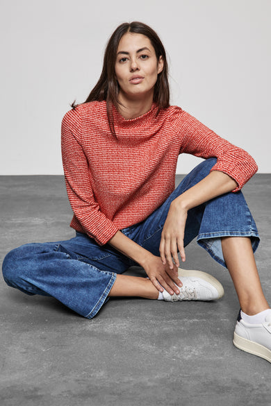 T-shirt orange de STREET ONE, manches longues, porté avec un jean large et des baskets blanches.
